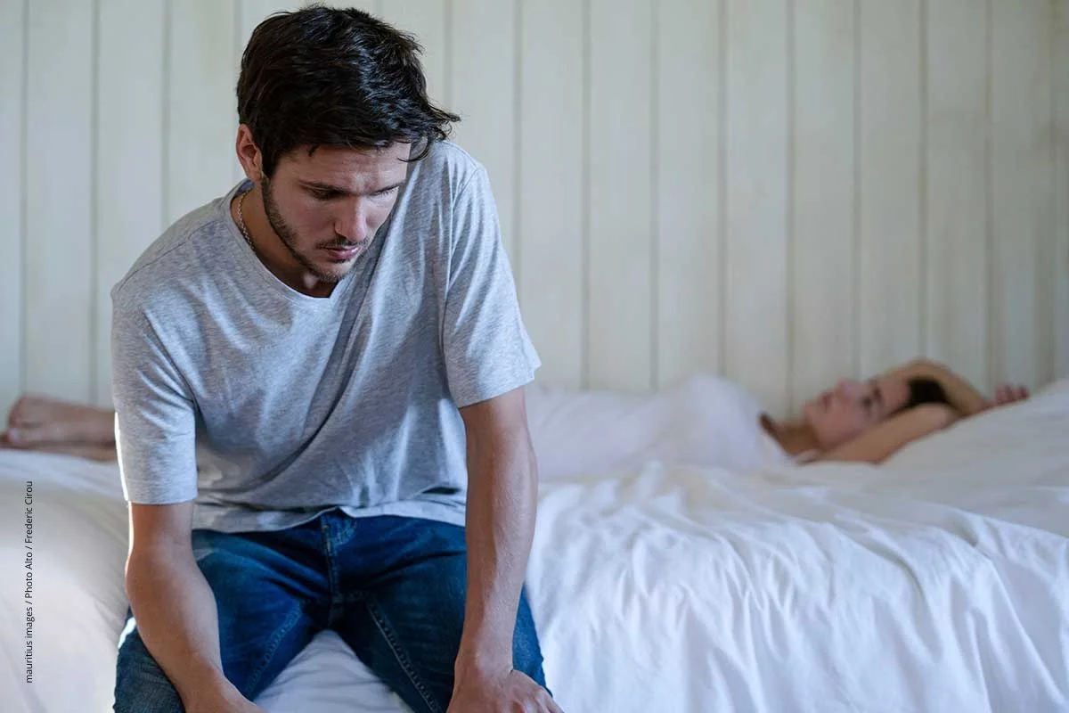 Paar sitzt frustriert auf dem Schlafzimmerbett. Der Plan, durch Coitus interruptus zu verhüten, kann leicht schiefgehen.