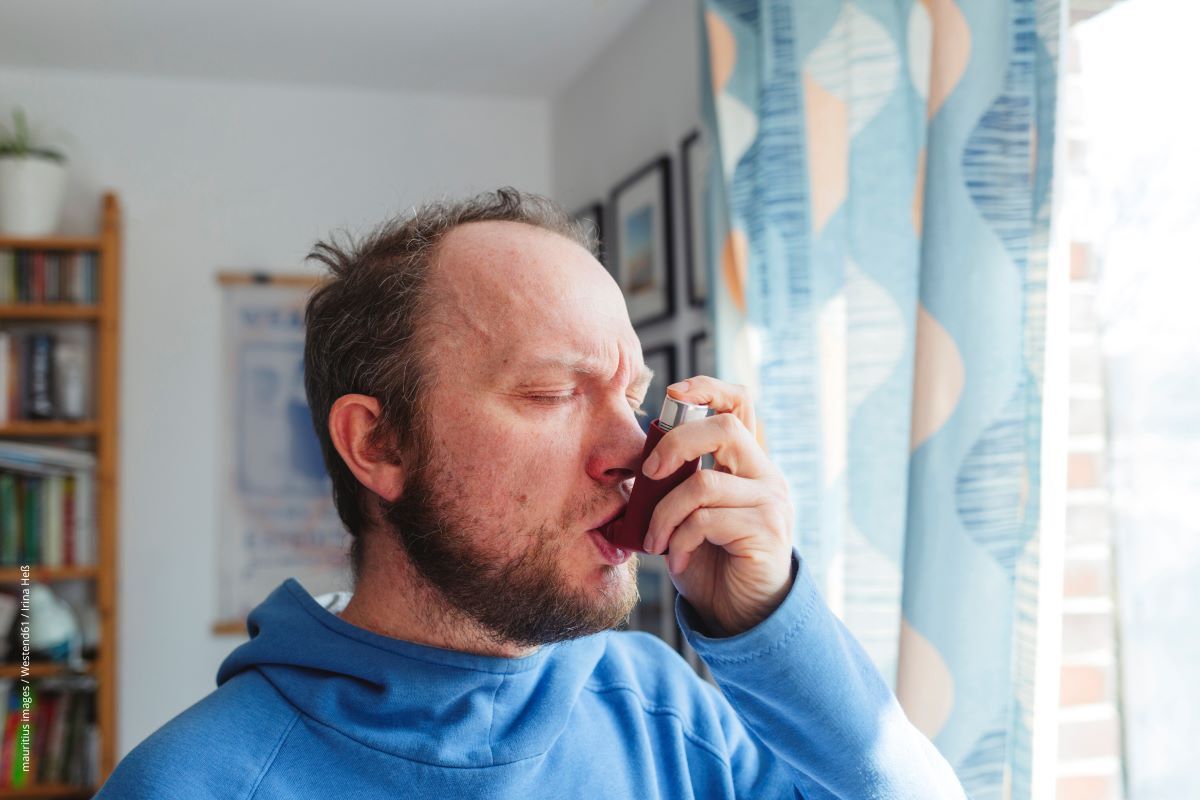 Ein Mann mit Asthma verwendet ein Dosieraerosol.