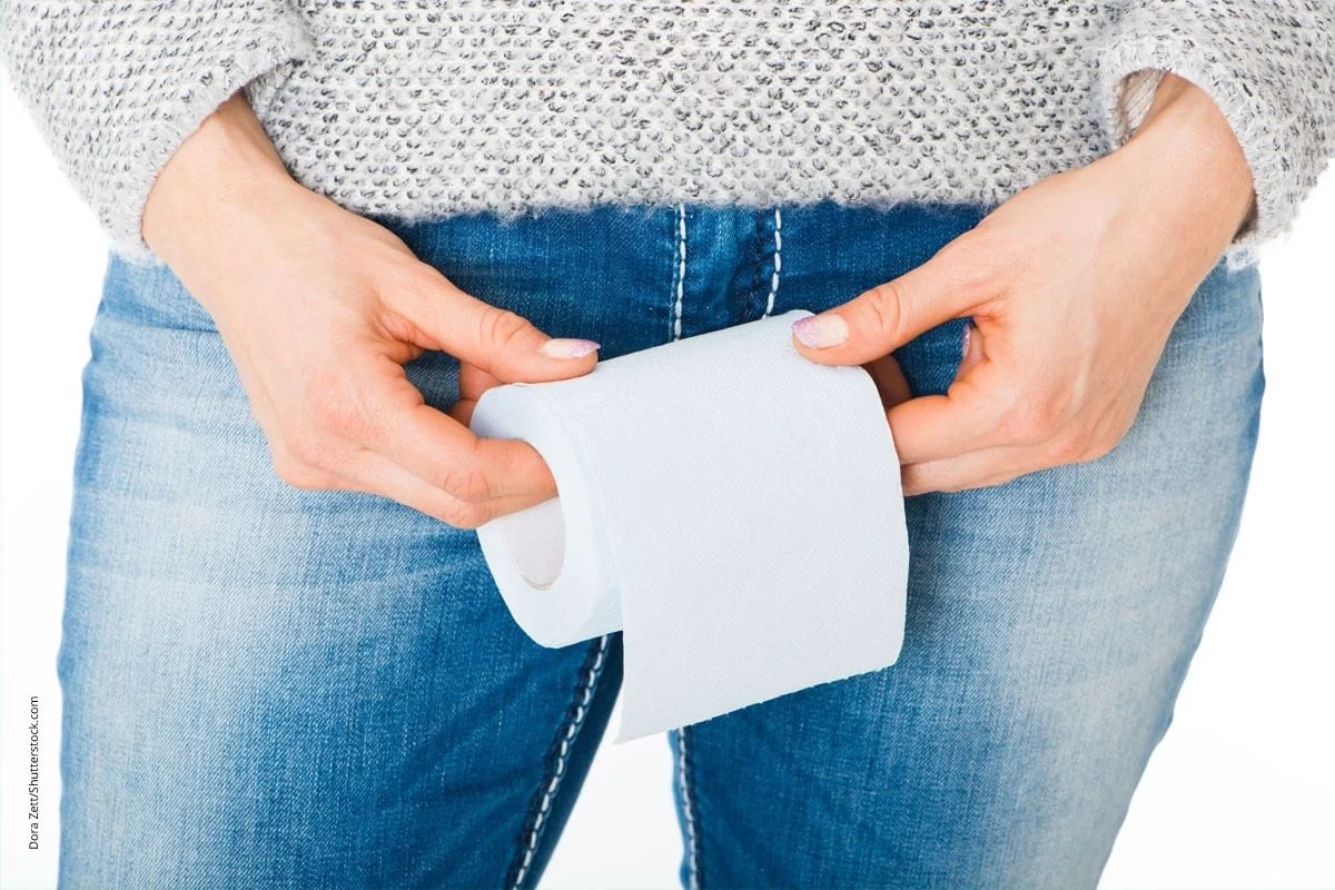 Frau hält Toilettenpapierrolle vor sich. Unwillkürlicher Harnabgang und versträrkter Harndrang sind häufige Probleme.