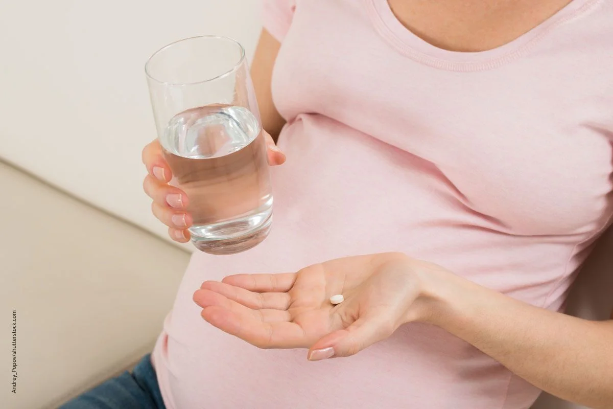 Schwangere Frau bei der TAbeltteneinnahme. Jod ist einer der Mineralstoffe, die in der Schwangerschaft unbedingt ausreichend zu VerfÃ¼gung stehen sollten. 