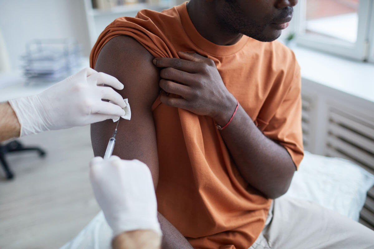 Mann erhält eine Spritze in den Arm. Zur spezifischen Immuntherapie sind viele Injektionen nötig.