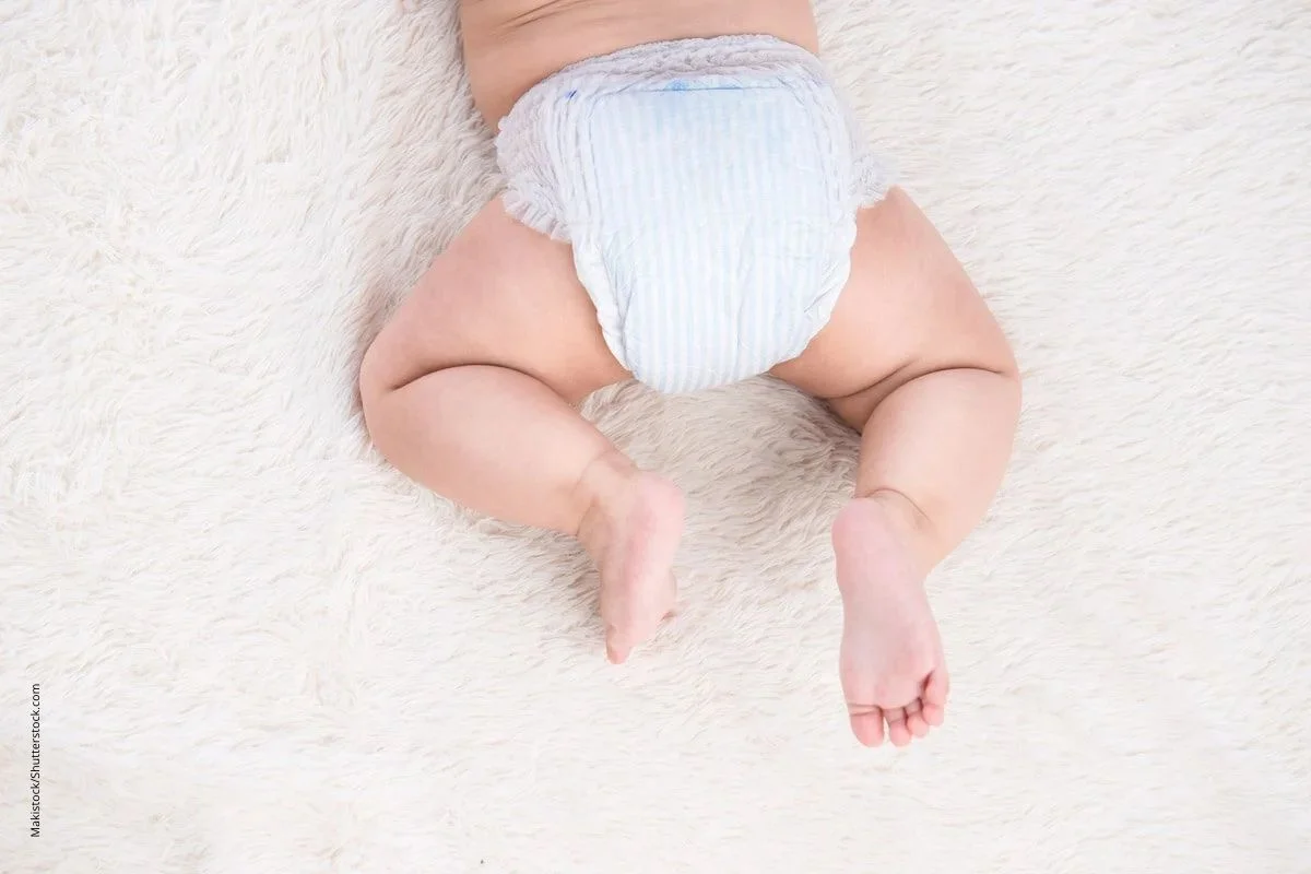 Baby mit Windel krabbelt aus dem Bild. Unter Windeln kann sich ein Windelausschlag entwickeln